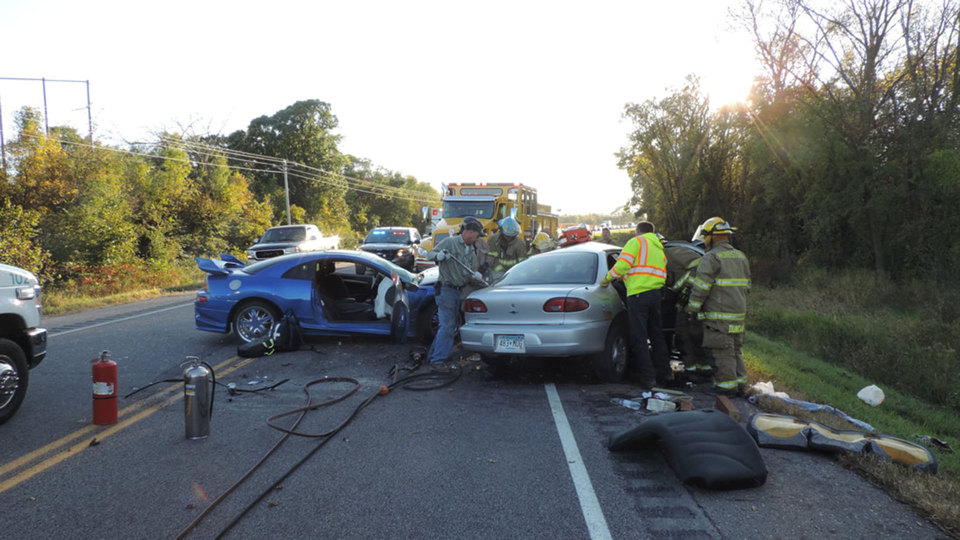 white and blue sedans in crash with emergency responders