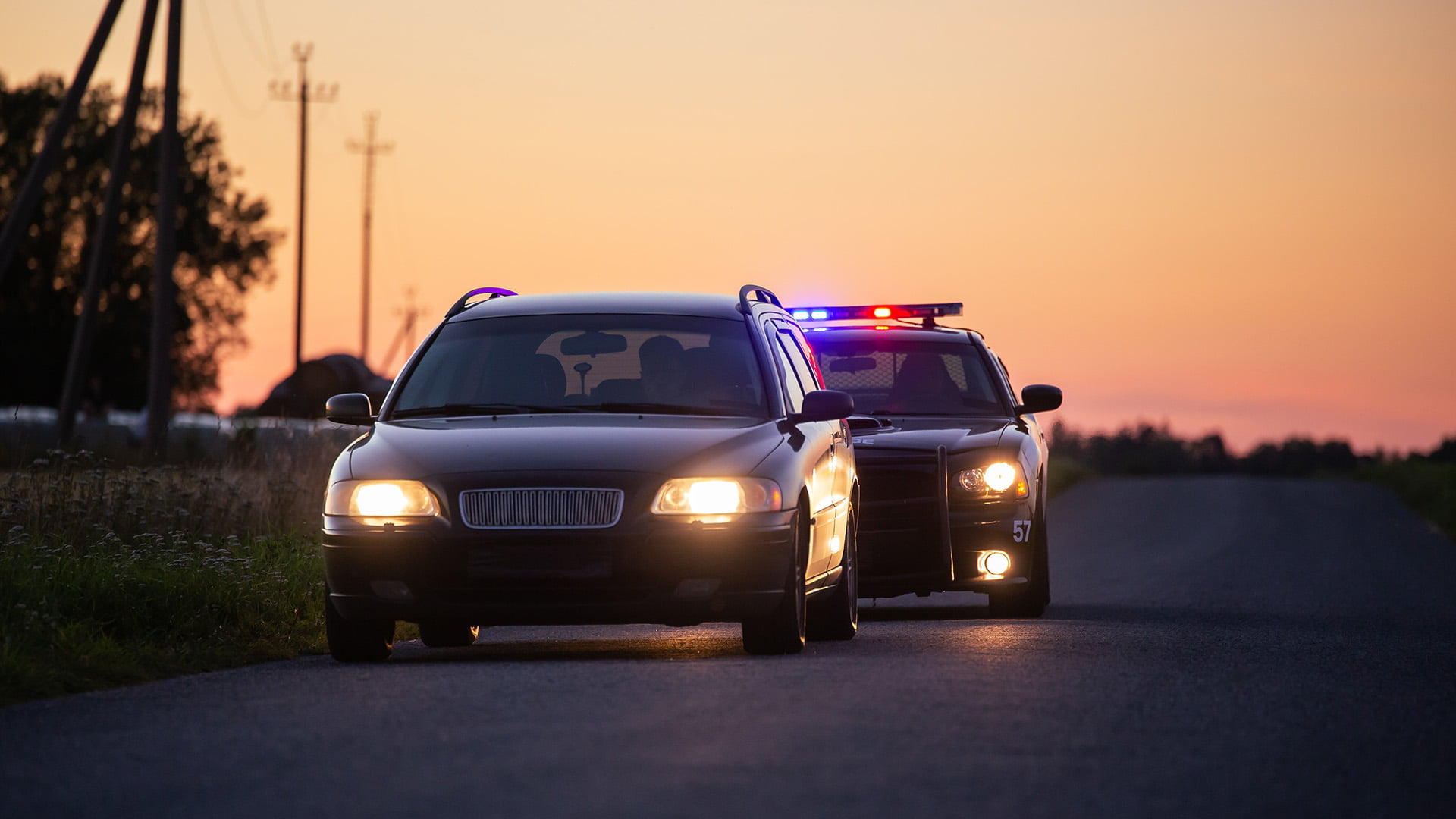 police car pulling over car at sunset