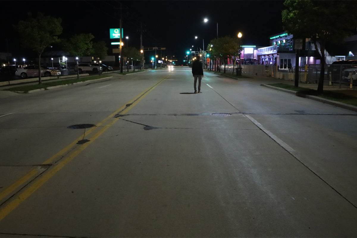 person standing on road in the dark